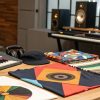 Indie musician surrounded by visual branding elements like album art, social media graphics, and logos, highlighting the impact on their career today