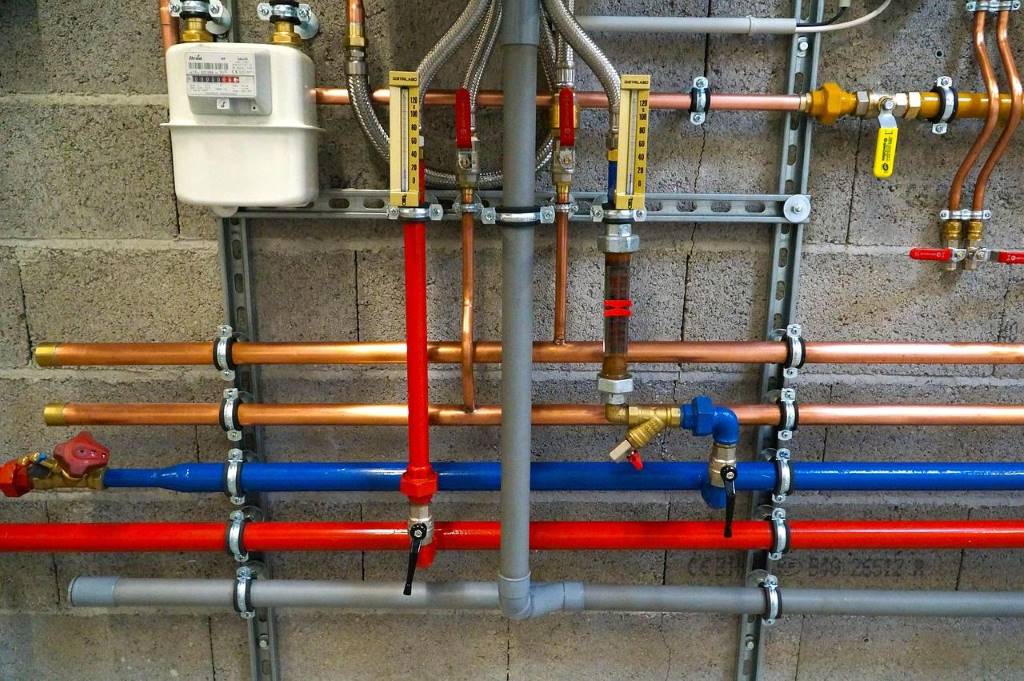 Plumber adjusting water pressure regulator in a residential Houston home setting