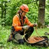 Arborist inspecting a climbing rope outdoors.