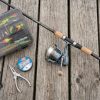 A beginner spinning rod and reel laid out on a wooden dock.