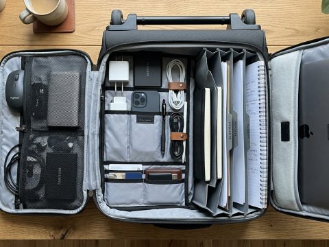 Professional commuter pulling a sleek wheeled laptop bag in a train station