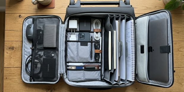 Professional commuter pulling a sleek wheeled laptop bag in a train station